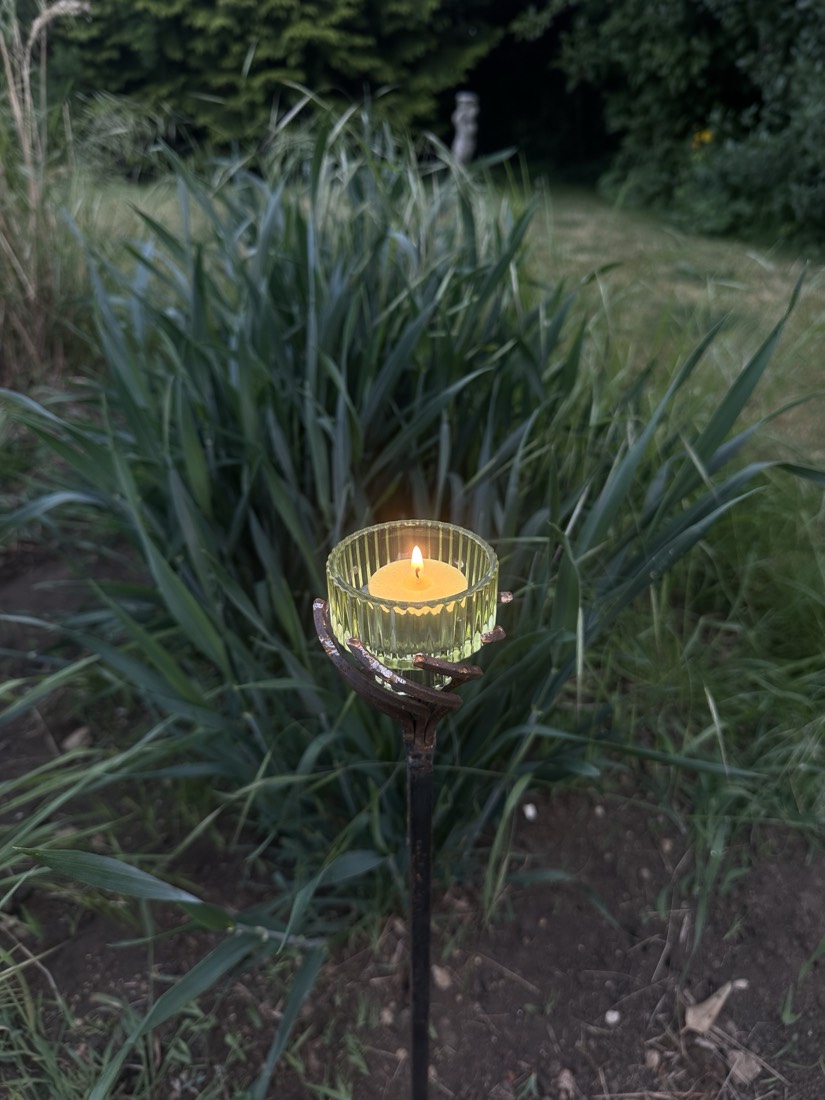Steel candle holder lit at dusk