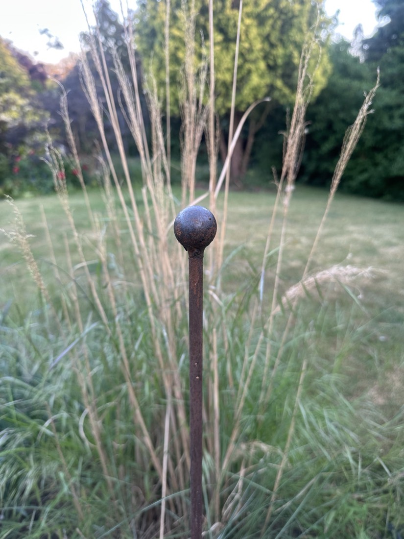 Pair of steel plant supports in a flower bed